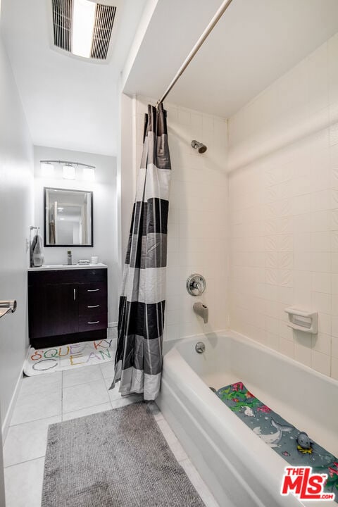 bathroom featuring tile patterned floors, vanity, and shower / tub combo with curtain