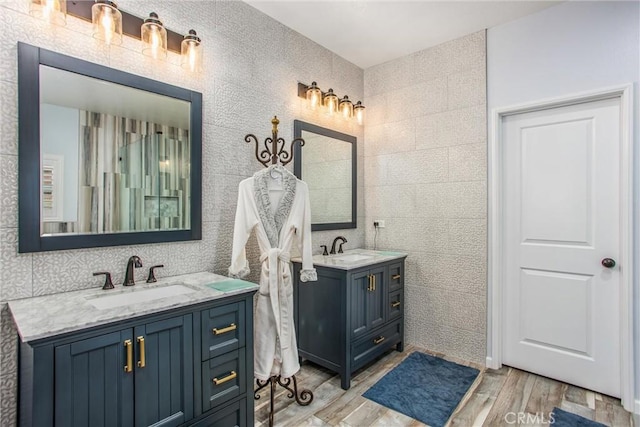 bathroom with vanity, hardwood / wood-style flooring, and tile walls