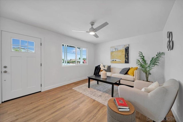 living room with ceiling fan, a wealth of natural light, and light hardwood / wood-style flooring