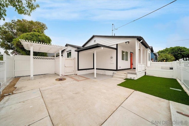 rear view of property with a pergola and a lawn