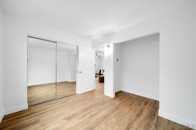 unfurnished bedroom featuring wood-type flooring and a closet