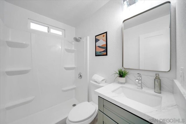 bathroom with toilet, vanity, and a shower