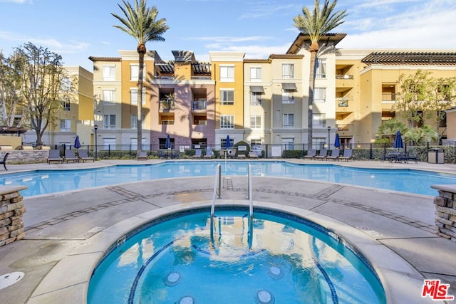 view of swimming pool featuring a hot tub