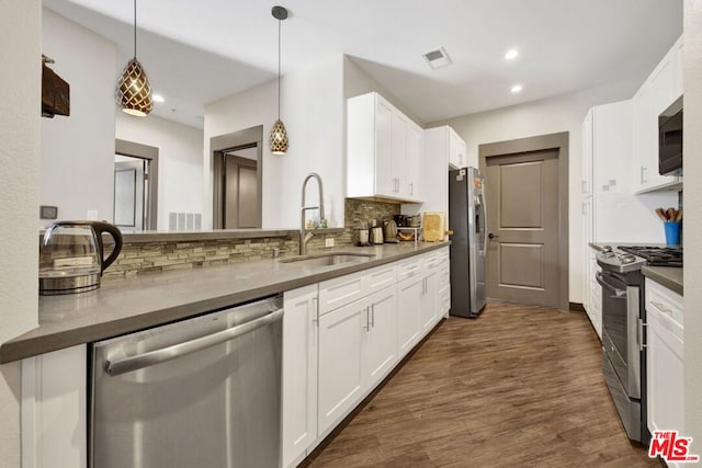 kitchen with stainless steel appliances, white cabinetry, dark hardwood / wood-style floors, and sink