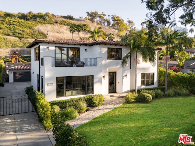 mediterranean / spanish-style house with a front yard and a balcony