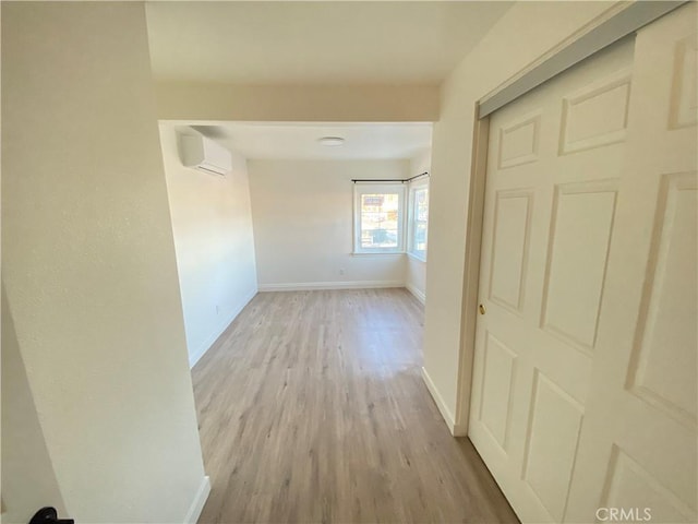 hallway featuring light hardwood / wood-style flooring and a wall unit AC