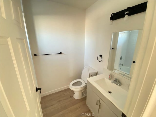 full bathroom with washtub / shower combination, toilet, wood-type flooring, and vanity