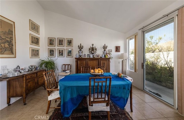 dining space with lofted ceiling and light tile patterned flooring