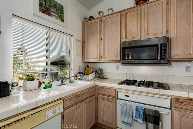 kitchen featuring tile countertops, sink, white appliances, and light brown cabinets