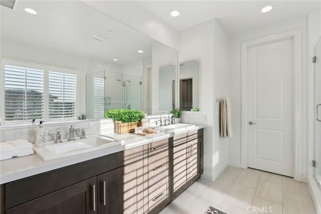 bathroom with tile patterned floors, a shower with door, and vanity