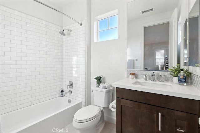 full bathroom featuring vanity, tiled shower / bath combo, decorative backsplash, and toilet