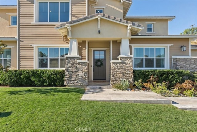 doorway to property featuring a lawn