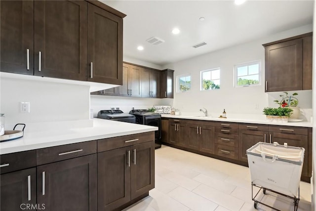 kitchen featuring independent washer and dryer, dark brown cabinetry, and sink