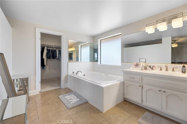 bathroom featuring vanity, tile patterned flooring, and a relaxing tiled tub