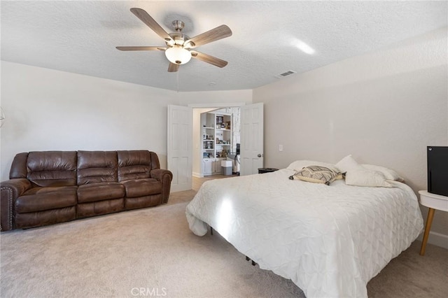 bedroom featuring a textured ceiling, ceiling fan, and light colored carpet