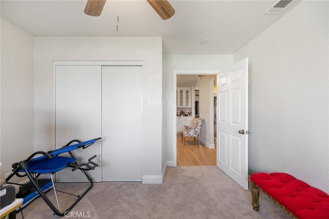 interior space featuring ceiling fan and light colored carpet