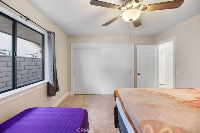 bedroom with ceiling fan, a closet, and light carpet