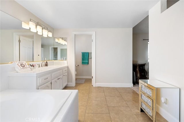 bathroom featuring toilet, vanity, a tub, and tile patterned floors