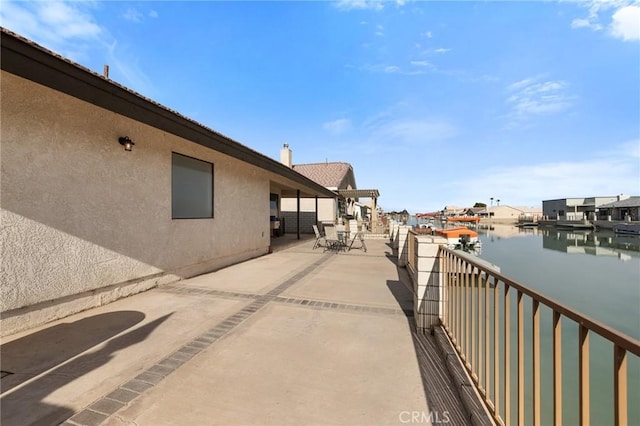 view of patio with a water view and a balcony