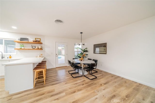 dining area with light wood-type flooring and sink