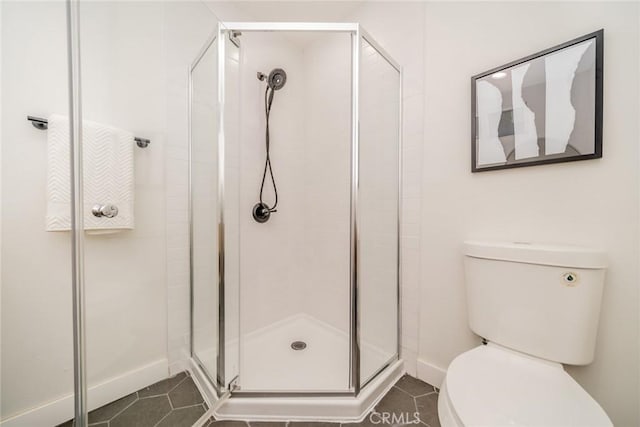 bathroom featuring a shower with shower door, tile patterned floors, and toilet