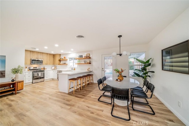 dining room featuring light wood-type flooring and sink