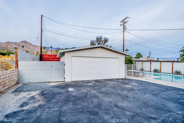 garage with a mountain view and a fenced in pool