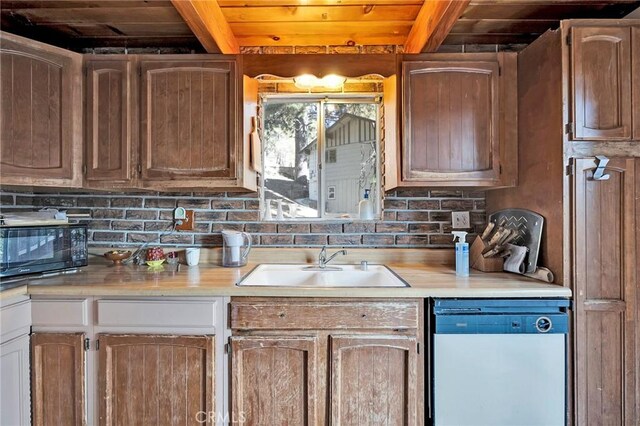 kitchen featuring beam ceiling, sink, dishwasher, and wood ceiling