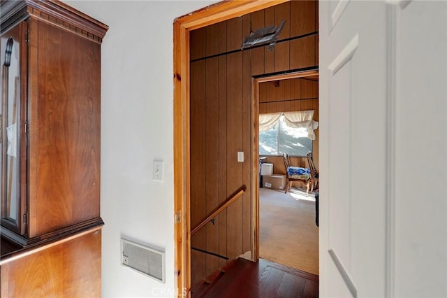 corridor with carpet and wood walls