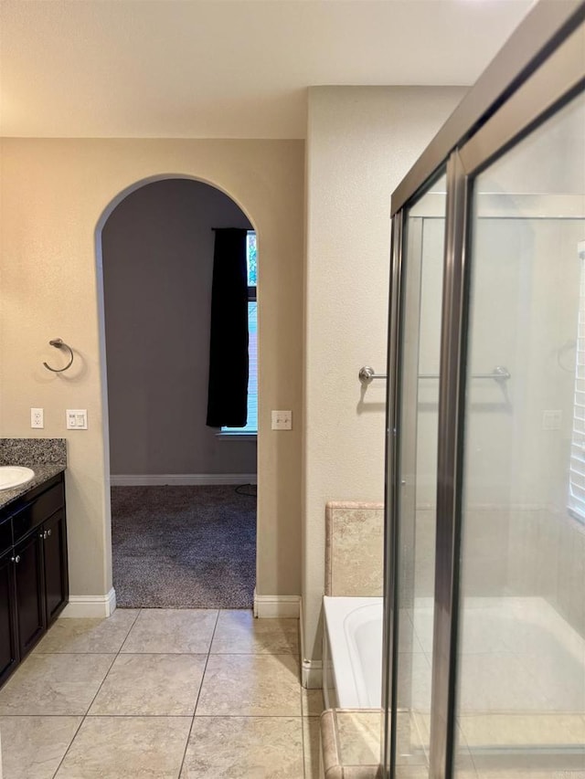 bathroom featuring vanity, a bathing tub, and tile patterned flooring