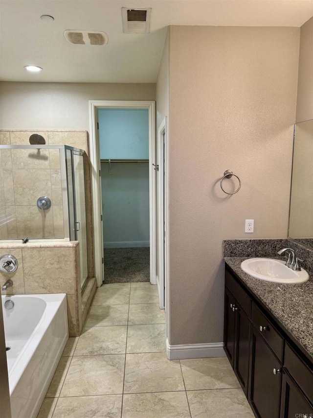 bathroom with tile patterned flooring, separate shower and tub, and vanity