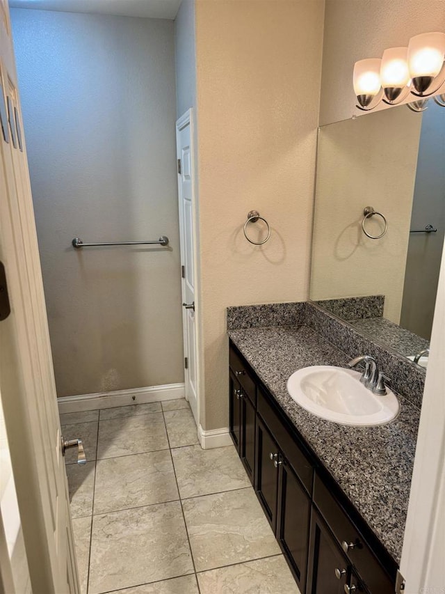 bathroom featuring vanity, a chandelier, and tile patterned flooring