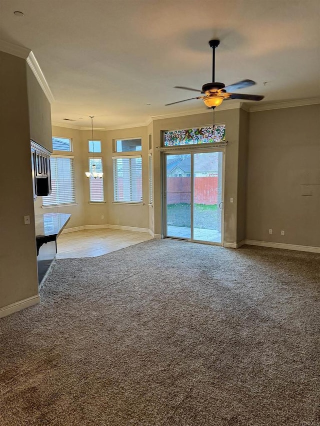 unfurnished living room with ceiling fan, ornamental molding, and carpet flooring