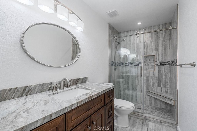 bathroom with toilet, walk in shower, and vanity