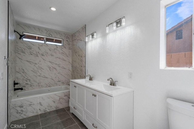 full bathroom featuring toilet, vanity, tile patterned floors, and tiled shower / bath