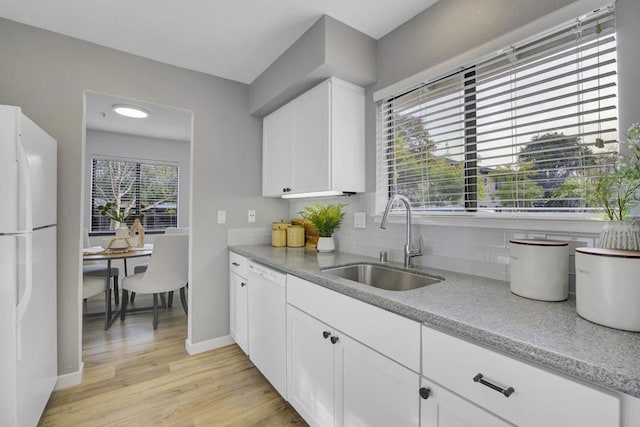 kitchen with sink, light wood-type flooring, white cabinets, white appliances, and backsplash