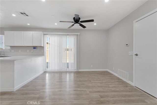 unfurnished living room featuring ceiling fan and light hardwood / wood-style flooring