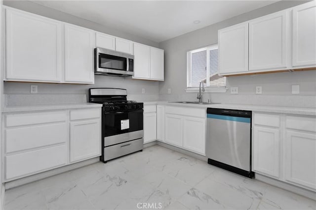 kitchen featuring stainless steel appliances, white cabinets, and sink