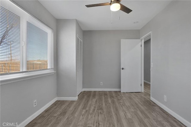 unfurnished bedroom featuring a closet, light hardwood / wood-style floors, and ceiling fan