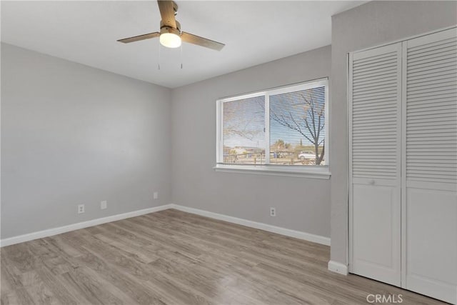 unfurnished bedroom featuring ceiling fan, a closet, and light hardwood / wood-style flooring