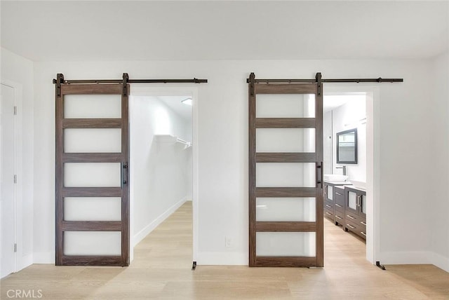 foyer entrance with a barn door and light wood-type flooring