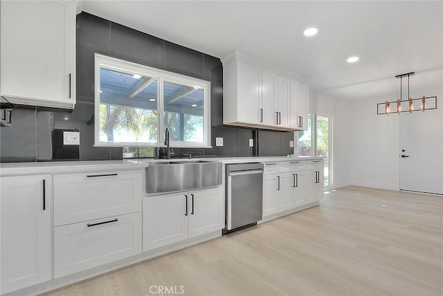 kitchen with white cabinetry, light wood-type flooring, dishwasher, hanging light fixtures, and sink