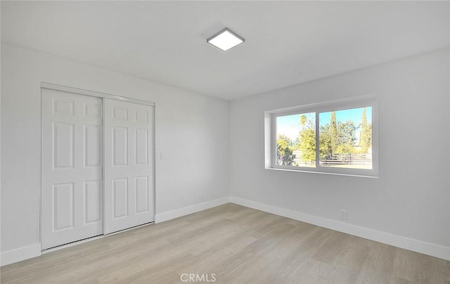 unfurnished bedroom with a closet and light hardwood / wood-style flooring