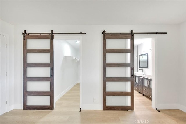 entryway with a barn door and light hardwood / wood-style flooring