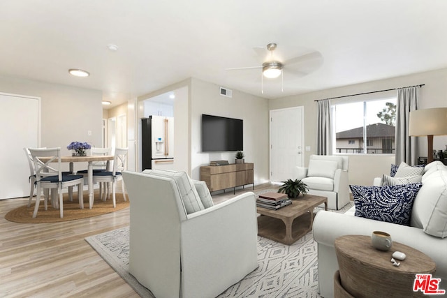 living room featuring light wood-type flooring and ceiling fan