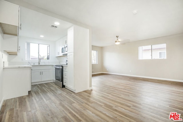 kitchen with sink, light hardwood / wood-style flooring, ceiling fan, appliances with stainless steel finishes, and white cabinetry