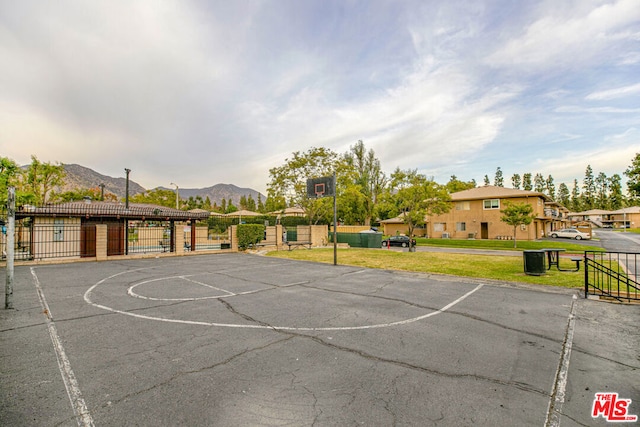 view of basketball court featuring a mountain view and a yard