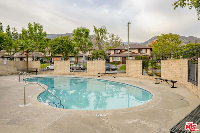 view of swimming pool featuring a mountain view and a patio