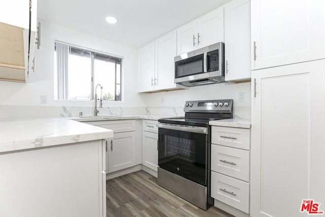 kitchen featuring white cabinetry, sink, hardwood / wood-style flooring, and appliances with stainless steel finishes