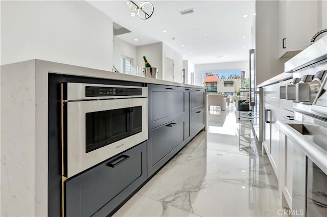 kitchen with wall oven, an inviting chandelier, and gray cabinets